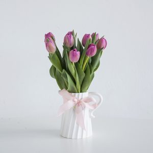 Tulips in a cute twisted white jug vase